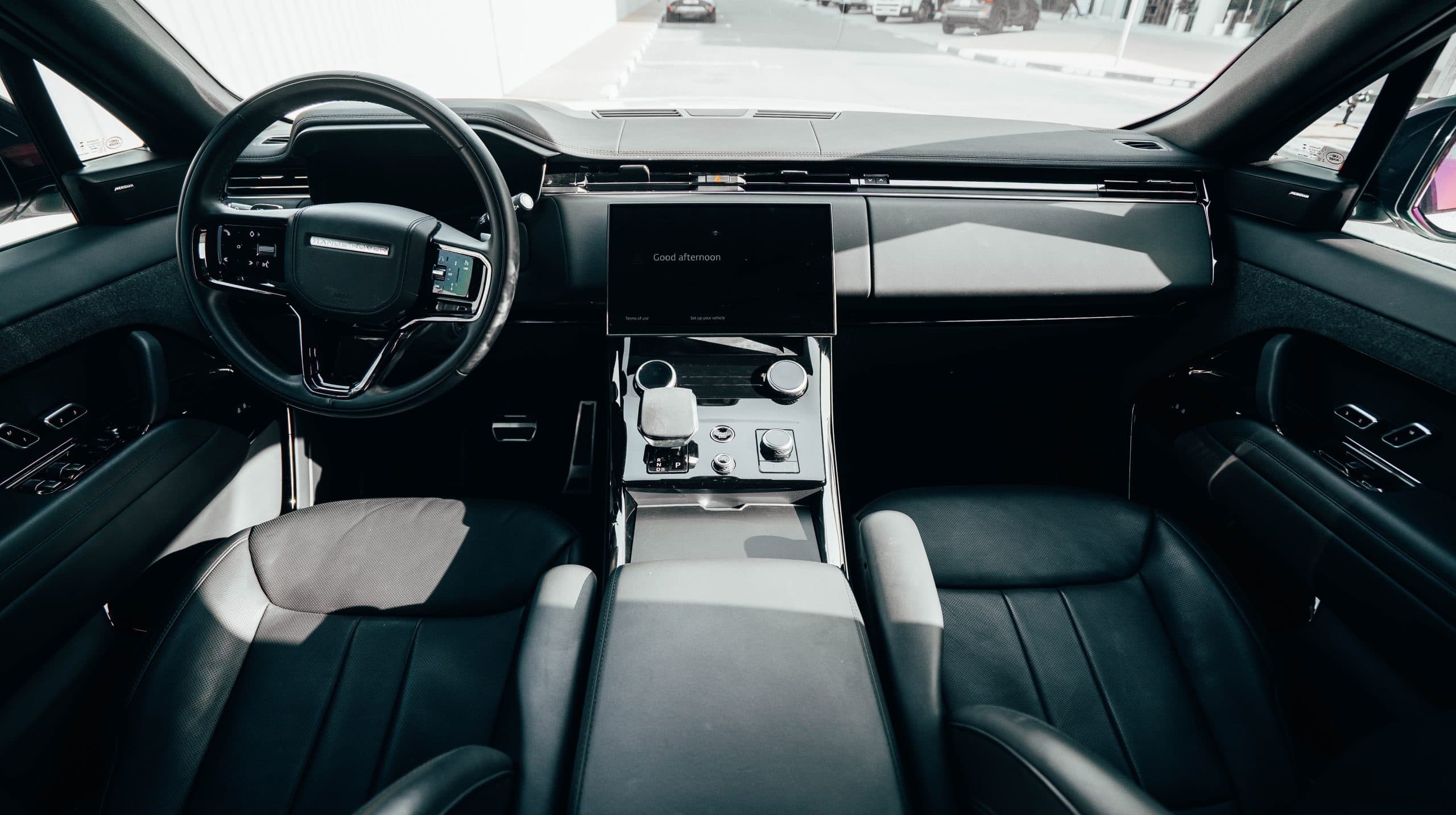Range Rover Sport cabin showing the steering wheel, navigation screen and centre-console controls